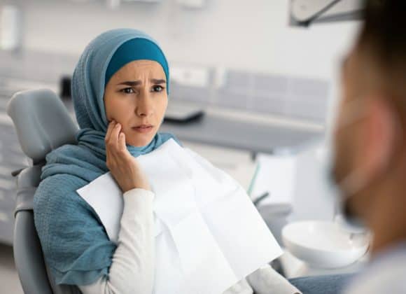 Dentists warn patients to stop using this popular product ASAP Teeth Problems. Muslim Female In Dentist Chair Showing Aching Tooth To Doctor